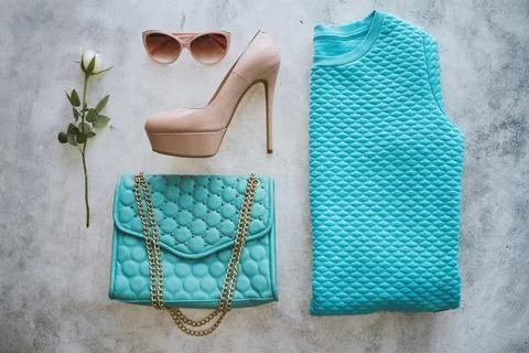 Set of clothes on the white background. Turquoise bag, sweater, beige high hills Stock Photos