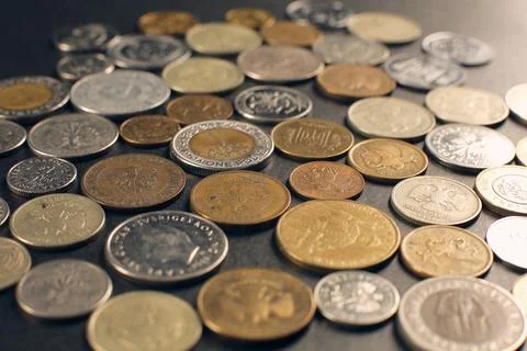 A set of coins of different countries located on a black background. Stock Photos