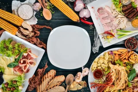 Set cold appetizers. Bacon, cheese, pate. Top view. On a wooden background. C Stock Photos