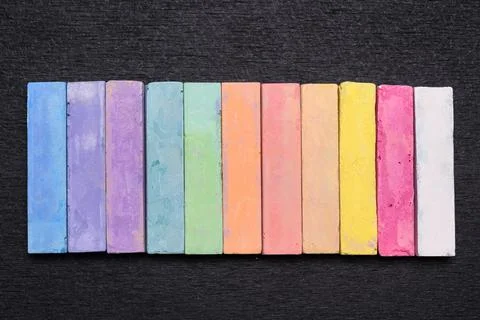 Set of colored crayons for children's creativity on a black chalk board Stock Photos