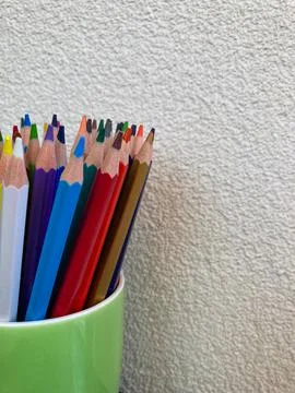 A set of colored pencils for drawing, stands in a green cup. Stock Photos
