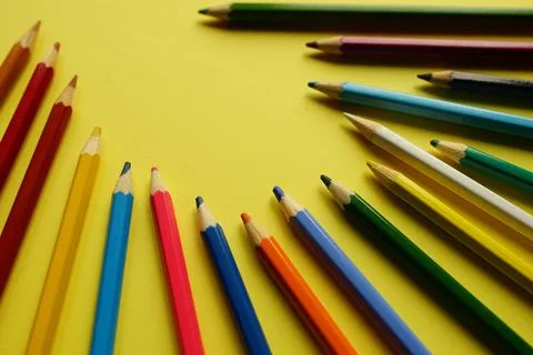 A set of colored pencils on a yellow table 库存照片