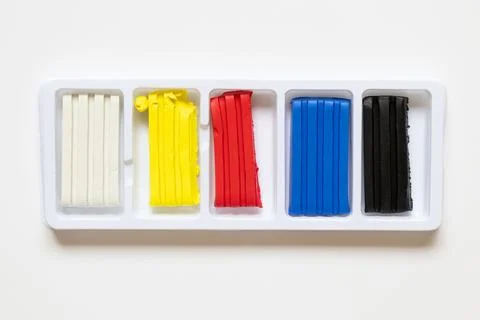 A set of colored play dough in plastic packaging on a white background. Mat.. Stock Photos