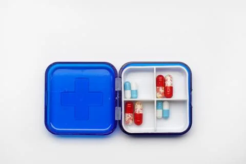 Set of colored tablets in a blue plastic box for several days, isolated on a Stock Photos