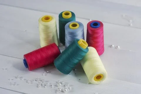 Set of colorful colored balls of thread on a light-colored wooden background. Stock Photos