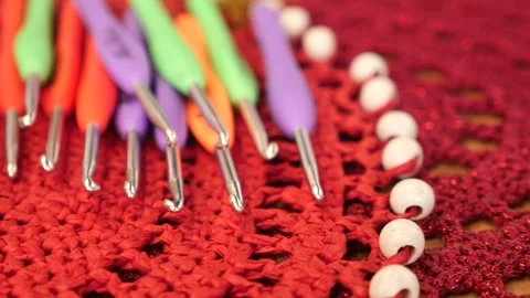Set of colorful crochet hooks lying on red handmade textile background with.. Stock Footage 333031874