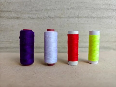 Set of Colorful Sewing Thread Spools in a Row on Neutral Background Stock Photos