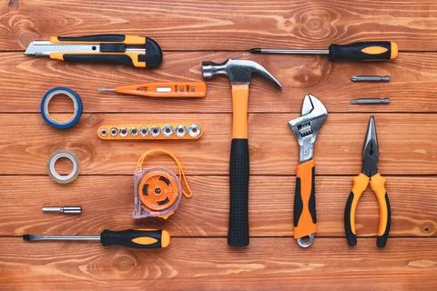 Set of construction tools on a wooden background. Hammer, wrench, pliers and Stock Photos
