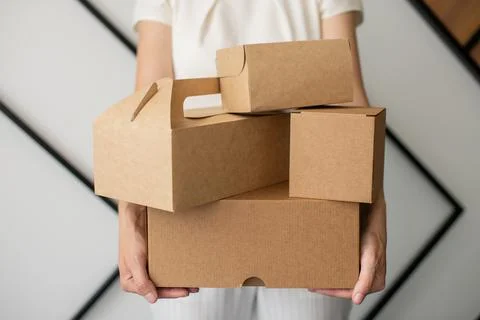 A set of craft boxes and packages in the hands of a person without a face Stock Photos