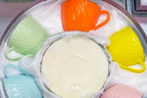 Set of cups of different colors with saucers. Stock Photos