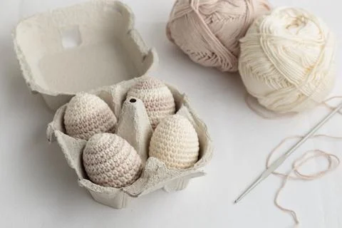 Set of cute easter crocheted eggs, pastel color in the eggbox Stock Photos