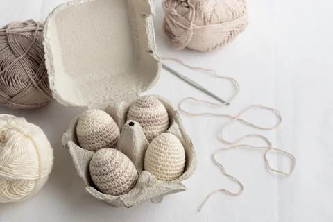 Set of cute easter crocheted eggs, pastel color in the eggbox Stock Photos