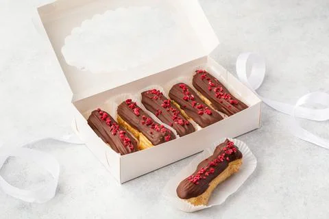 Set of decorated eclairs in paper box Stock Photos