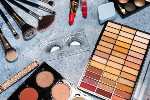 Set of decorative cosmetics, makeup brushes false eyelashes on a blue background Stock Photos