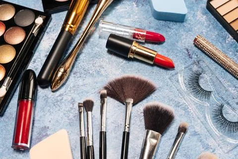 Set of decorative cosmetics, makeup brushes on a blue background. the view from Stock Photos