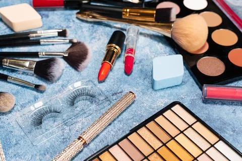 Set of decorative cosmetics, makeup brushes on a blue background. the view from Stock Photos