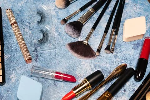 Set of decorative cosmetics, makeup brushes on a blue background. the view from Stock Photos