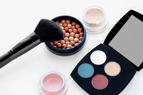 Set of decorative cosmetics on white background. Ball blush, cream eye shadow Stock Photos