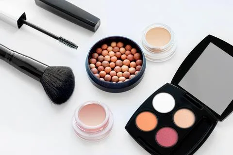 Set of decorative cosmetics on white background. Ball blush, cream eye shadow Stock Photos