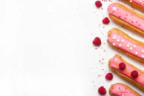 Set of delicious eclairs with pink raspberry glaze and sugar sprinkles on ... Stock Photos