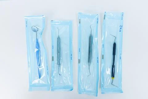 Set of Dental Instruments in Sterile Packaging for Oral Health Procedures and Stock Photos