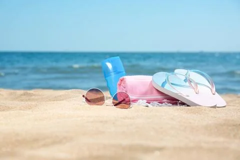 Set of different beach objects on sand near sea. Space for text Stock Photos