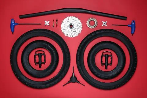 Set of different bicycle tools and parts on red background, flat lay Stock Photos