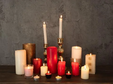 Set of different candles burning on table Stock Photos