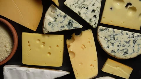 Set of different cheeses on black background. Various types of cheese rotates Stock Footage 302028916