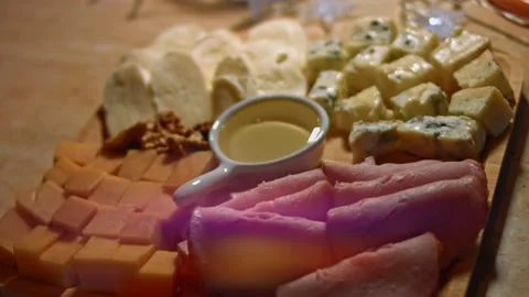 Set of different cheeses, pork ham, honey and greek nuts on a wooden tray Stock Footage 146490089