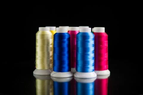 Set of different color sewing threads,on black background. Stock Photos