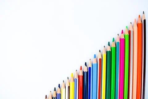 A set of different colored pencil crayons arranged from small to big on a whi Stock Photos