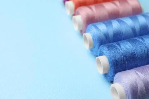 Set of different colorful sewing threads on light blue background, closeup... Stock Photos