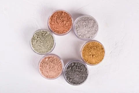 Set of different cosmetic clay mud powders on white background Foto stock