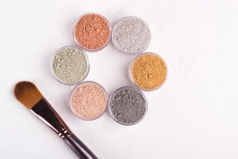 Set of different cosmetic clay mud powders on white background Foto stock