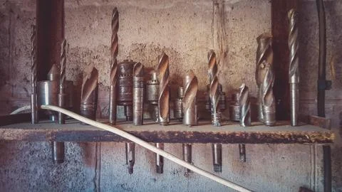 A set of different drills stand on a shelf in a row 스톡 사진