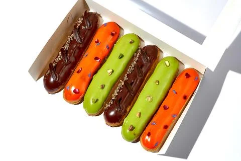 A set of different eclairs with different flavors in a packaging box. White.. Stock-Fotos