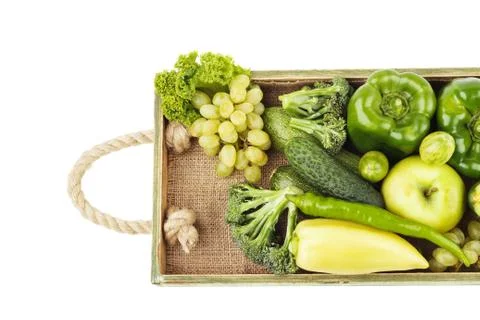 Set of different green fresh raw vegetables and fruits in the wooden tray Stock Photos