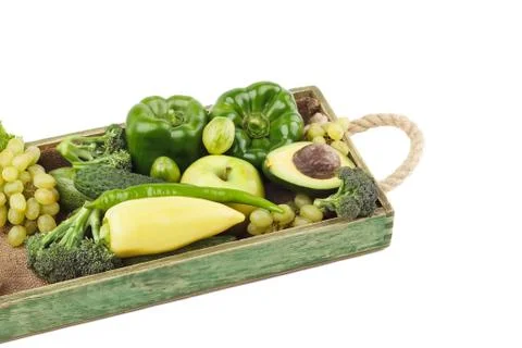 Set of different green fresh raw vegetables and fruits in the wooden tray Stock Photos