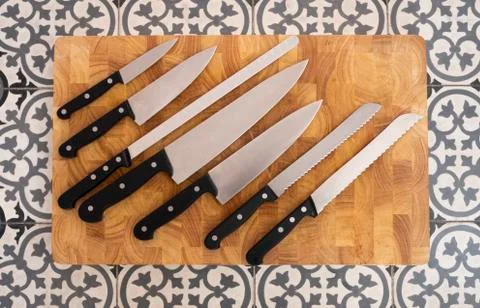 Set of different kitchen knives on wooden board Stock Photos