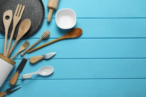 Set of different kitchen utensils on light blue wooden table, flat lay. Spa.. Stock Photos