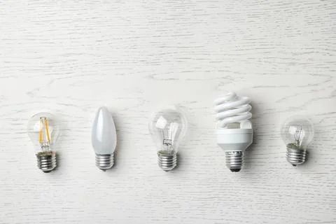 Set of different lamp bulbs on white wooden background, top view Stock Photos