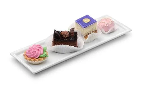 Set of different mini cakes on rectangular plate Set of different mini cak... Foto stock