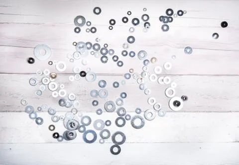 Set of different sizes of metal washers on an old wooden background. top view Stock Photos
