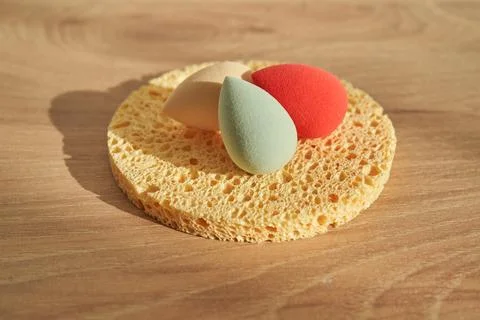 A set of different sponges: small colored ones and a large natural sponge. Stock Photos