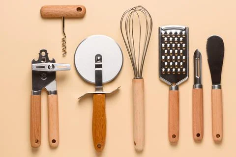 Set of different stainless steel kitchen utensils on beige background Stock Photos
