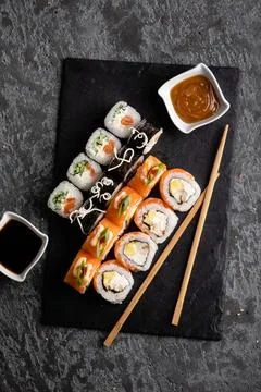 Set of different sushi rolls on a dark background. Sauce and chopsticks. Top Stock Photos