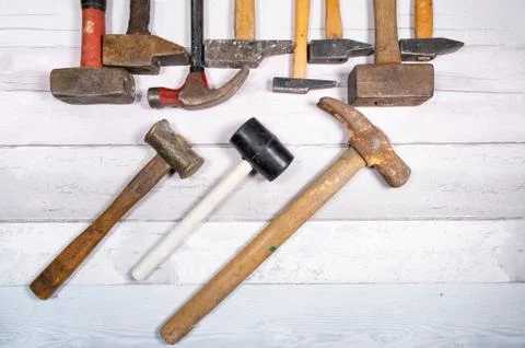 Set of different types of old hammers on a wooden background. top view. Stock Photos