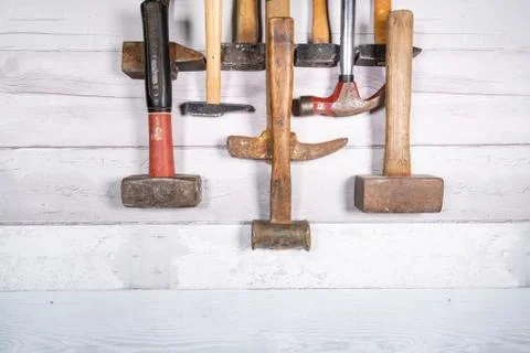 Set of different types of old hammers in line at the top of a space on a wood Foto stock
