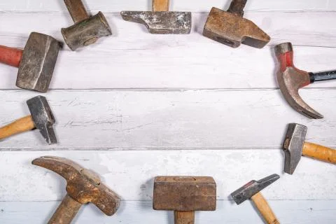 Set of different types of old hammers put in circles on a wooden background.  Stock Photos